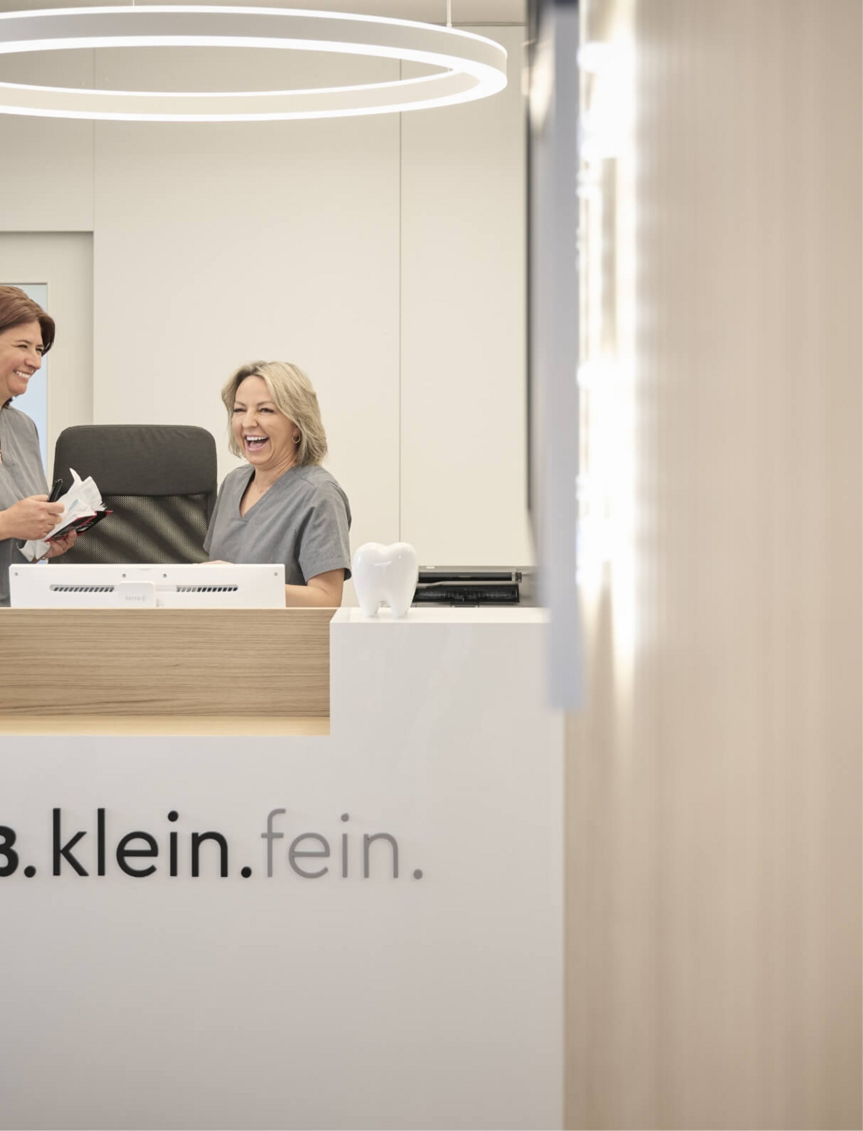 der Empfangstresen der Zahnarztpraxis groß.klein.fein ist mit dem Logo der Praxis geschmückt 